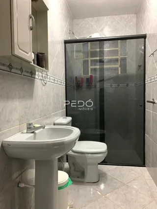 Foto de um banheiro com pia e vaso sanitário em cerâmica.