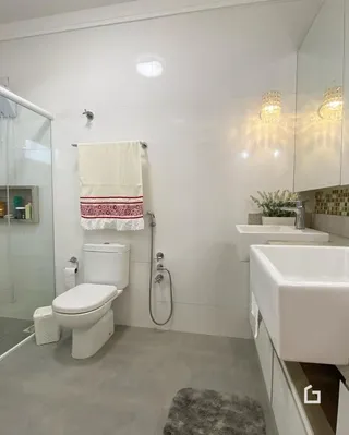 Interior de um banheiro moderno com revestimento claro.