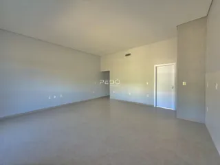 Ambiente interno de uma sala ampla e vazia.
