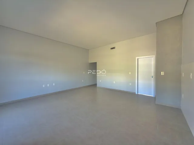 Ambiente interno de uma sala ampla e vazia.