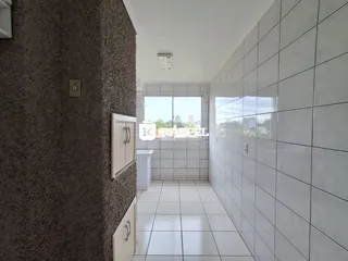 Corredor interno com piso de azulejos claros e paredes revestidas.