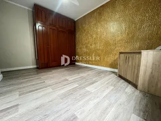 Quarto com armário de madeira e parede texturizada amarela.