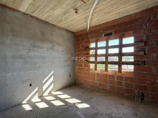 Interior de um espaço com paredes de tijolo aparente e teto de concreto.