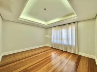 Sala de estar com piso de madeira e teto embutido.
