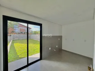 Interior de uma sala com porta de vidro que dá para um jardim.