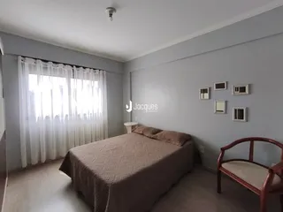 Quarto com cama e janela em ambiente claro.