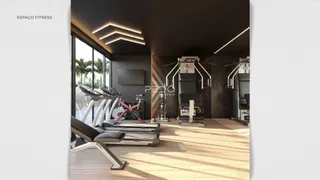 Uma sala de ginástica com equipamentos de treino e piso de madeira.