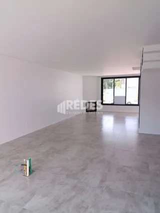 Ambiente interno de uma sala ampla com piso de cerâmica.