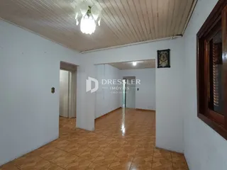 Corredor interno de uma residência com piso de cerâmica marrom.