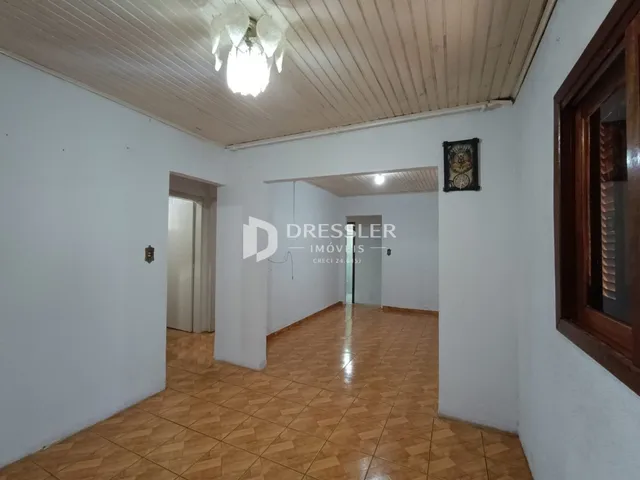 Corredor interno de uma residência com piso de cerâmica marrom.