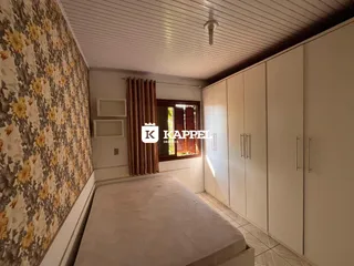 Quarto com cabeceira e armários embutidos em um ambiente bem iluminado.