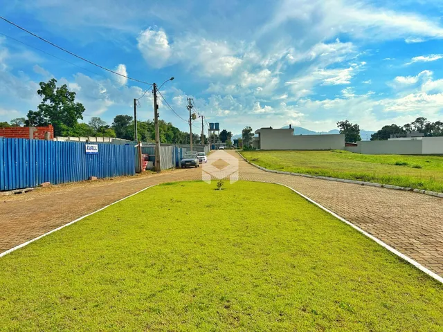 Vista externa de uma propriedade com cerca azul e gramado verde.