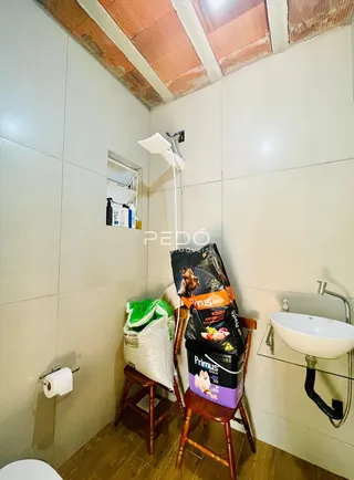Parede branca com teto inclinado e detalhes de madeira em um imóvel.