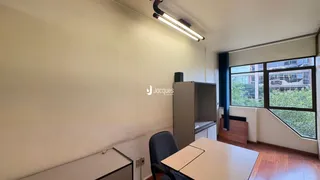 Ambiente interno de uma sala com piso de madeira e janela.