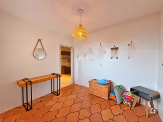 Ambiente interno de uma sala com piso de cerâmica terracota.