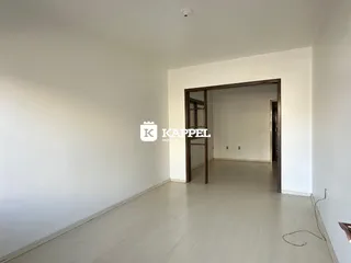 Ambiente interno com piso de madeira clara e paredes brancas.