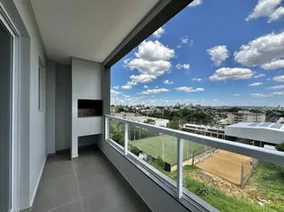 Vista da varanda com paisagem urbana e campos.