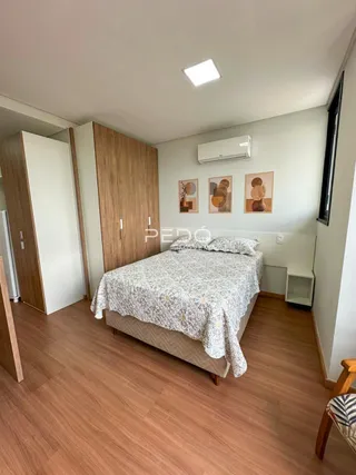 Quarto com cama e armário de madeira no interior da residência.
