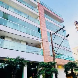 Fachada moderna de um edifício residencial em Lajeado, Brasil, com grandes janelas de vidro e varandas.