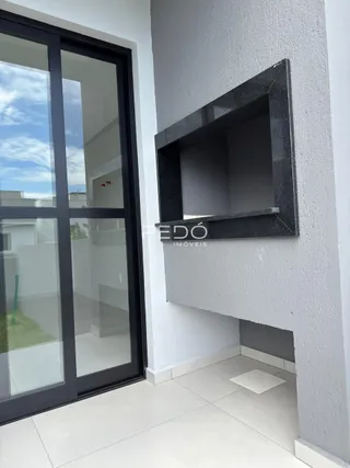 Parede interna com moldura escura e piso de cerâmica.