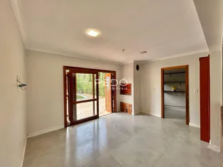 Interior de uma sala com porta de vidro abrindo para o exterior.