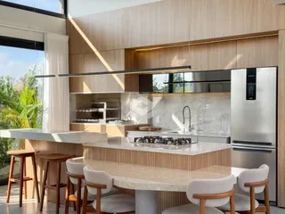 Cozinha moderna com ilha e mesa de jantar em um imóvel no Brasil.