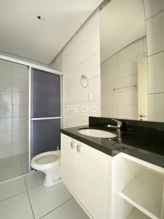 Foto de um banheiro com revestimento cerâmico branco e bancada escura.
