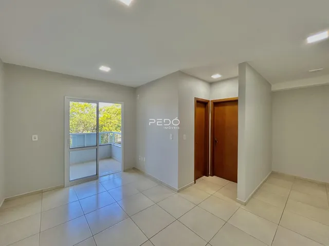 Sala de estar com piso de cerâmica e porta de vidro abrindo para a varanda.