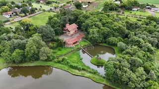 Vista aérea de uma residência cercada por vegetação e um corpo d'água em Lajeado.