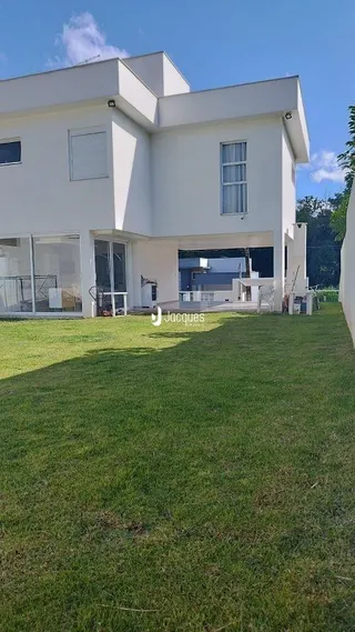Fachada de uma casa branca com jardim verde em Lajeado, Brasil.