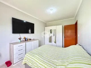 Quarto com cama e armários brancos em um imóvel no Brasil.