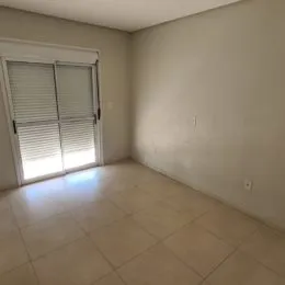 Foto de um cômodo interno com paredes brancas e piso de cerâmica.
