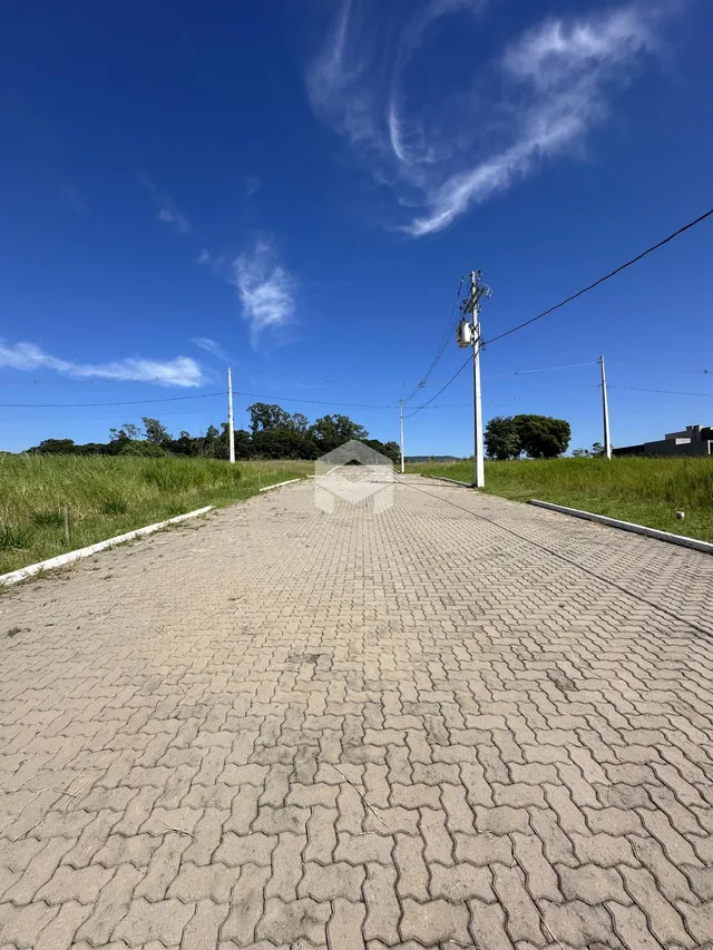 Uma estrada pavimentada se estende por uma área gramada sob um céu azul.