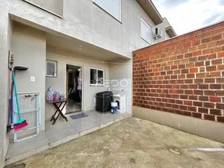 Vista da fachada de uma residência com parede de tijolos vermelhos.