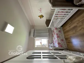 Quarto com piso de madeira e janela no interior da propriedade.