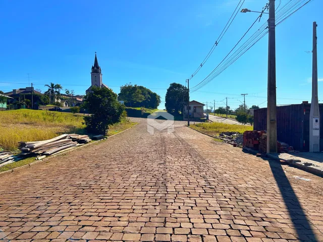 Vista de uma rua pavimentada em Lajeado, Brasil, com vegetação ao redor.