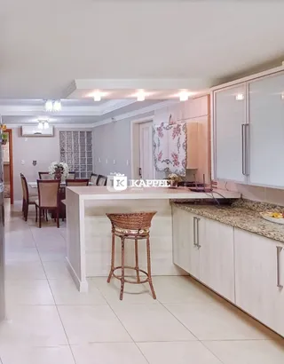 Cozinha com armários brancos e ilha de balcão em um apartamento.