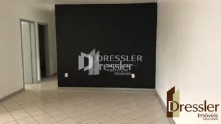 Vista interna de um corredor com parede escura e piso claro.