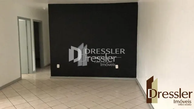 Vista interna de um corredor com parede escura e piso claro.