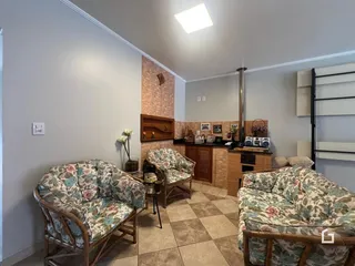 Sala de estar com sofás estampados e piso de cerâmica.