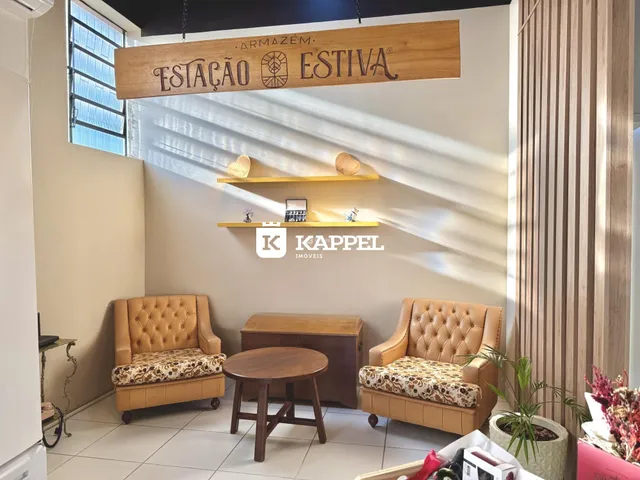 Sala de estar com duas poltronas de couro e uma mesa de centro de madeira.