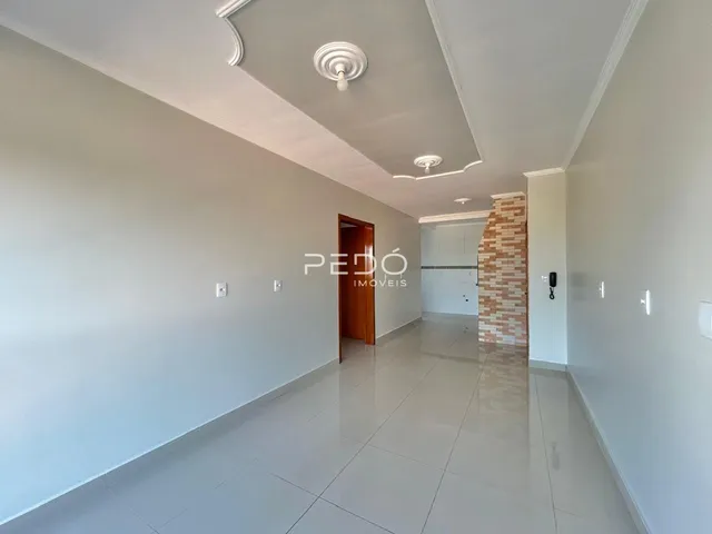 Vista do corredor interno de uma residência com piso de cerâmica clara.