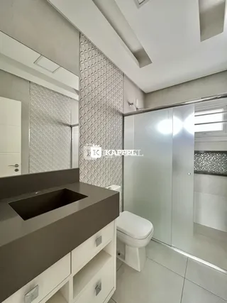 Foto de um banheiro moderno com bancada escura e box de vidro.
