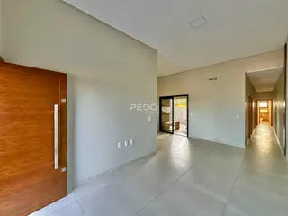 Hall de entrada com piso de cerâmica claro e paredes brancas.