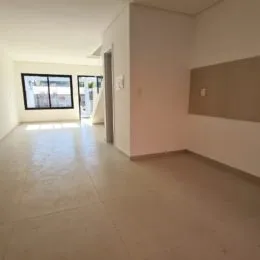 Hall de entrada com piso claro e paredes brancas.