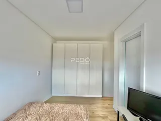 Quarto com paredes brancas e um guarda-roupa branco em um imóvel no Brasil.