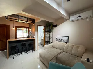 Sala de estar com sofá e móveis de madeira em um imóvel no Brasil.