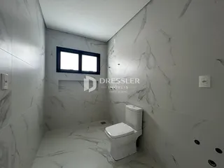 Imagem de um banheiro com revestimento em mármore claro.