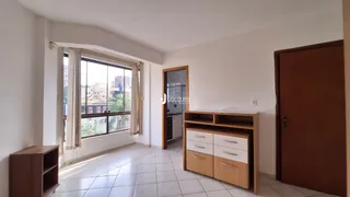 Interior de uma sala com janela de vista para a cidade.