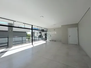 Vista interna de um ambiente moderno com piso claro e grade de vidro.